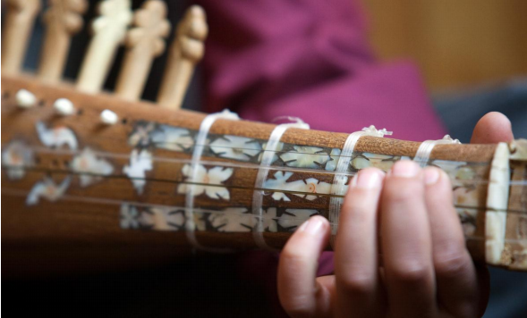 Afghan student playing musical instrument 