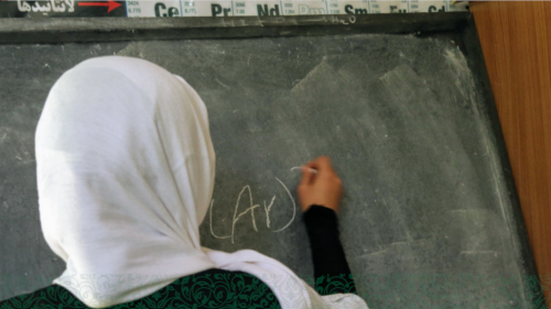 Girl writing on chalkboard